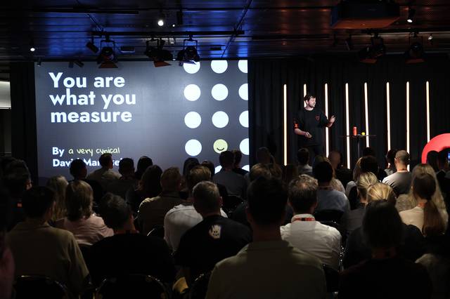 A croud looking at David Mannheim on stage during CJAM 2025 with keynote "You are what you measure"